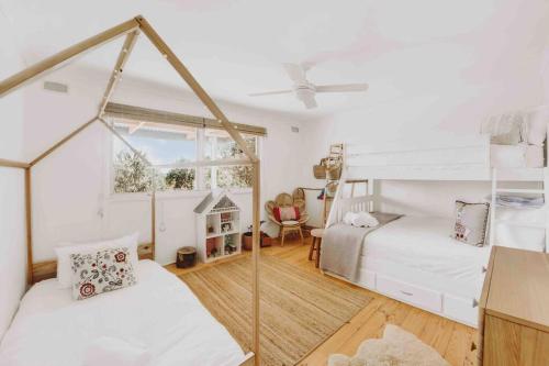 a bedroom with two bunk beds and a window at Whimsical Willunga Getaway in Willunga