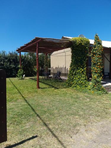 eine Pergola in einem mit Efeu bewachsenen Garten in der Unterkunft La Mora Cabañas in Villa Urquiza