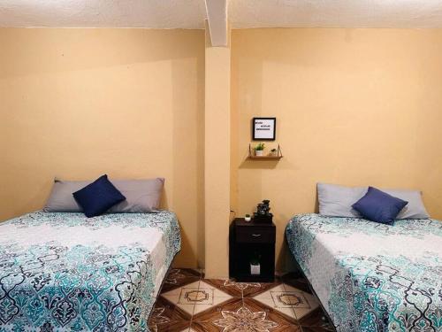 twee bedden naast elkaar in een kamer bij Casa Nicolas #1 in San Pedro La Laguna