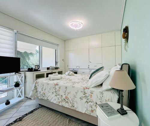 ein Schlafzimmer mit einem Bett mit einer Lampe und einem Fenster in der Unterkunft Wisteria in Nafpaktos
