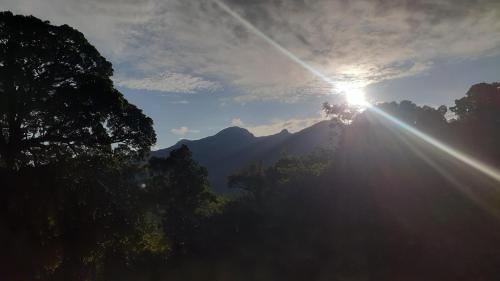 a sun shining in the sky over a forest of trees at Abimansala Resort in Hunnasgiriya