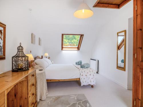 1 dormitorio con cama y tocador de madera en Cobbles Cottage, en Talgarth