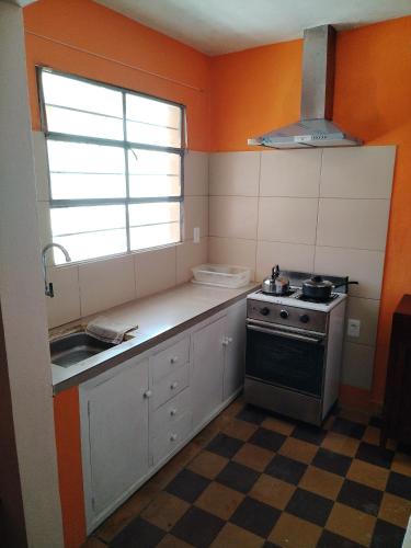 a kitchen with a stove and a sink and a window at La Casa de los Viejos in Minas