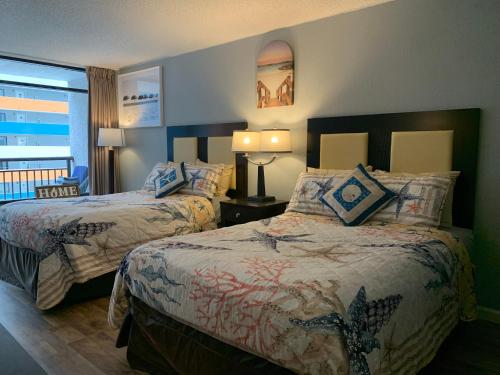 a hotel room with two beds and a window at Lee's Myrtle Beach Condo in Myrtle Beach