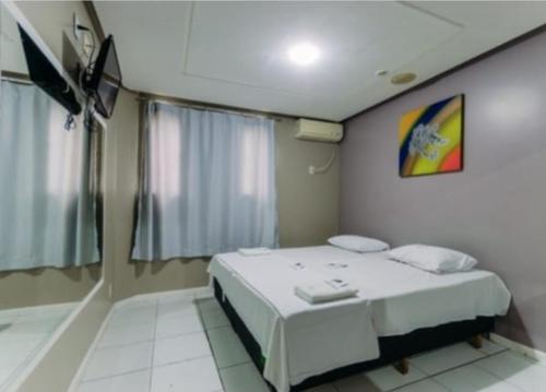 a bedroom with a white bed in a room at Iapi Hotel in Salvador