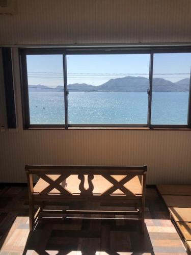 a room with a bench in front of a large window at Beach Villa Tachibana in Onomichi