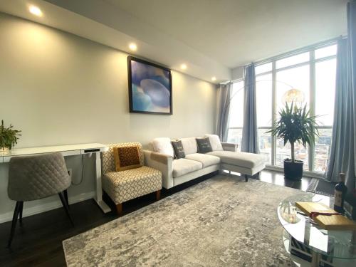 sala de estar con sofá, sillas y ventana en TVHR - Luxury Condos in Heart of Downtown, en Toronto
