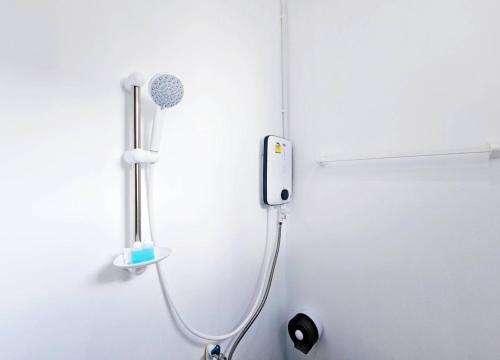 a shower in a bathroom with a phone on the wall at P.California Inter Hostel in Nang Rong
