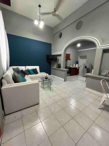 a living room with a white couch and a blue wall at Puerta Azul in Tampico