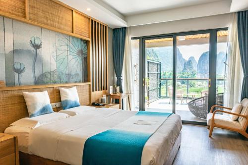 a hotel room with a bed and a balcony at Yangshuo Zen Garden Resort in Yangshuo
