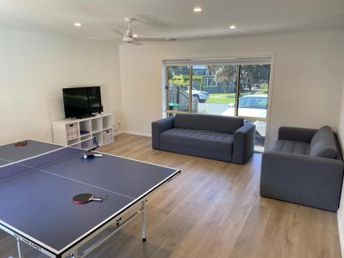a living room with a ping pong table and chairs at R&R by the Bay in prime location in Dromana