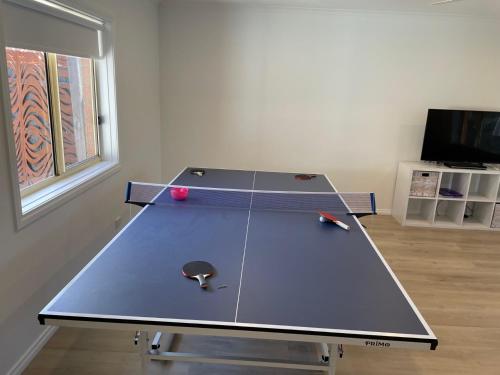 a ping pong table with a ball on top of it at R&R by the Bay in prime location in Dromana
