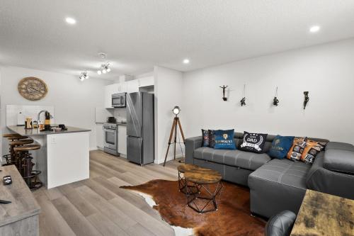 a living room with a couch and a kitchen at GlobalStay Cranbrook Townhome Suites in Calgary