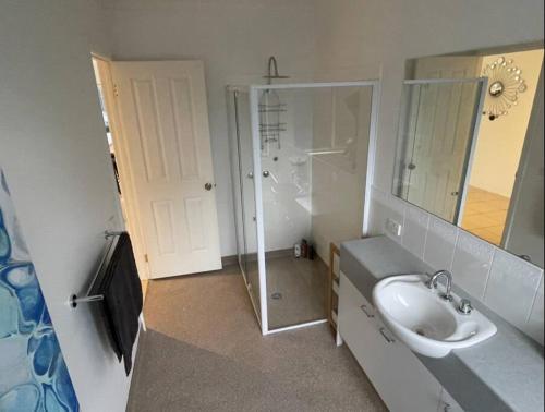 a bathroom with a sink and a shower and a mirror at R&R by the Bay in prime location in Dromana
