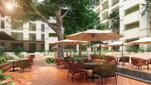 布城的住宿－棕櫚花園度假酒店，一个带桌椅和遮阳伞的户外庭院。