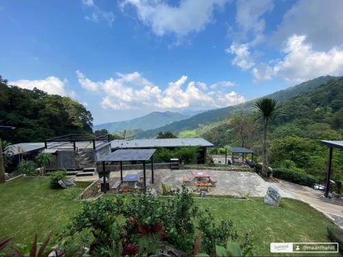 a garden with a pavilion with mountains in the background at ม่านฟ้าฮิลล์ ภูชี้ฟ้า 