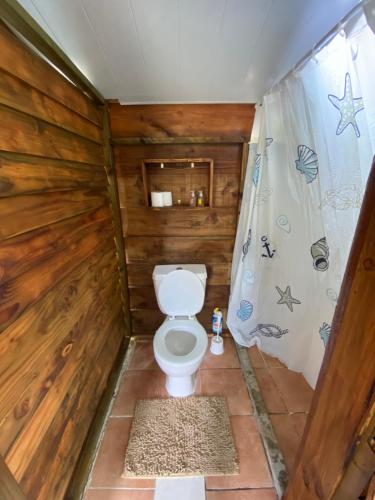 - une salle de bains avec toilettes dans une cabine en bois dans l'établissement Fare Tahima, à Fare