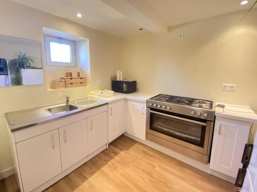 une cuisine avec un évier et une cuisinière four supérieur dans l'établissement Apartment in Loctudy by Lodonnec Beach, à Loctudy