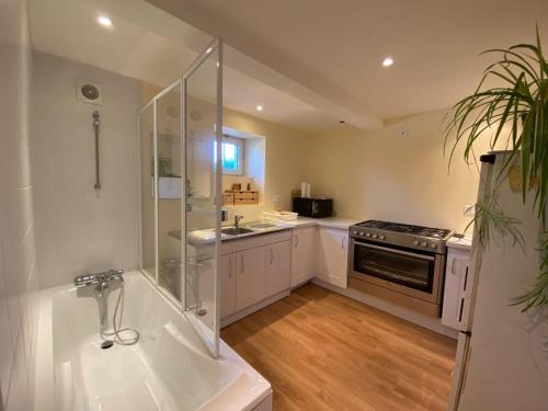 Il comprend une cuisine équipée d'une douche, d'un évier et d'une cuisinière. dans l'établissement Apartment in Loctudy by Lodonnec Beach, à Loctudy