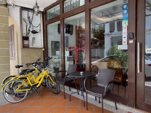 duas bicicletas estacionadas ao lado de uma mesa e cadeiras em Inn Residence 18 em George Town