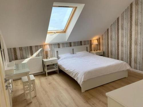 a bedroom with a large bed and a window at Comfortable holiday home for 5 people, Grzybowo in Grzybowo