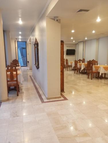 a dining room with tables and chairs in a room at Hotel Alcala del Rio in Santiago