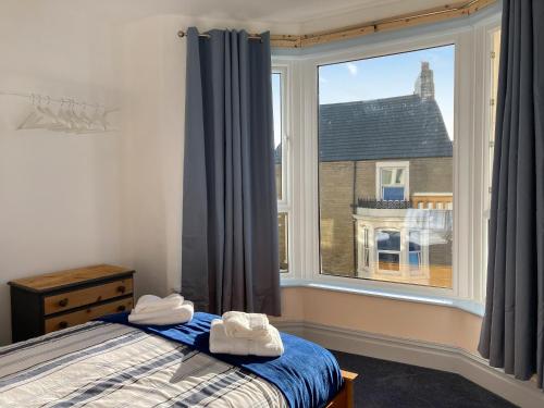 a bedroom with a bed and a large window at Blue Sands in Morecambe