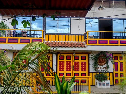 a yellow and red building with a balcony at Confortable Apartamento a 20 mt del Parque Principal in Salento