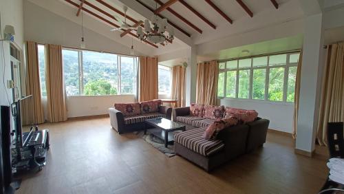 a living room with two couches and a tv at Smile Hub Kandy Penthouse apartment in Kandy