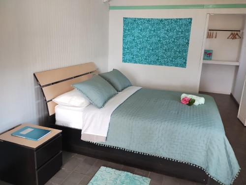 Schlafzimmer mit einem Bett mit blauer und weißer Bettwäsche in der Unterkunft Cabañas Kitai in Hanga Roa