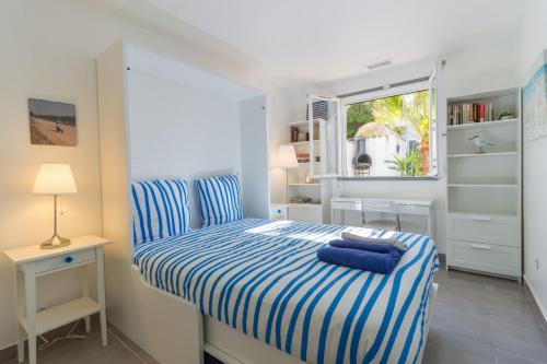 a small bedroom with a blue and white bed at VILLA LES PALMIERS in Palavas-les-Flots