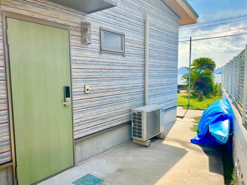 a door to a house with an air conditioner next to it at Beach Villa Tachibana in Onomichi