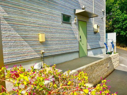 a green door on the side of a house at Beach Villa Tachibana in Onomichi