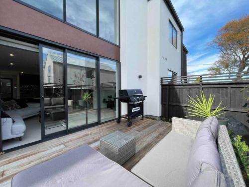 balcón de una casa con sofá y piano en Luxury 3 Bedroom Home With Double Garage en Christchurch