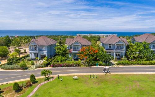 Une rangée de maisons dans une rue avec l'océan dans l'établissement Family Villa in Sea Links Beach City Mũi Né, à Mui Ne