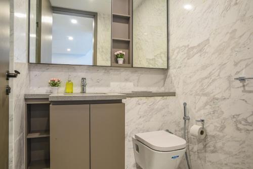 a bathroom with a toilet and a sink and a mirror at Eaton KLCC Suites By Elite in Kuala Lumpur