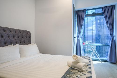 a bedroom with a large bed with a large window at Eaton KLCC Suites By Elite in Kuala Lumpur