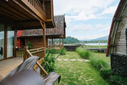 a porch of a house with a hammock in the yard at Villa Kedisan Lakeview in Kintamani