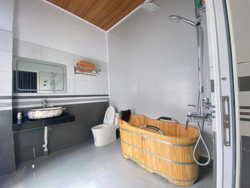 a bathroom with a wooden bath tub next to a toilet at Bảo Lạc - Sunny Homestay in Bảo Lạc