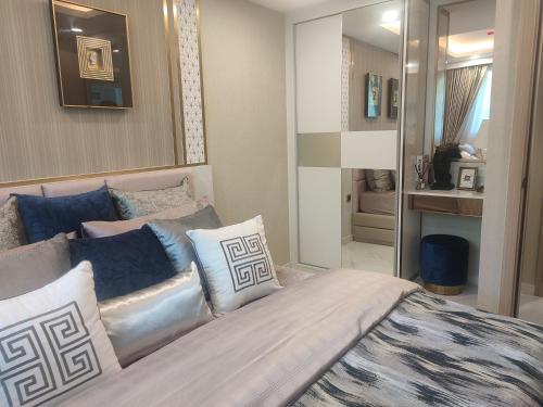 una camera da letto con un grande letto con cuscini blu e bianchi di 夏威之宿 a Pattaya North