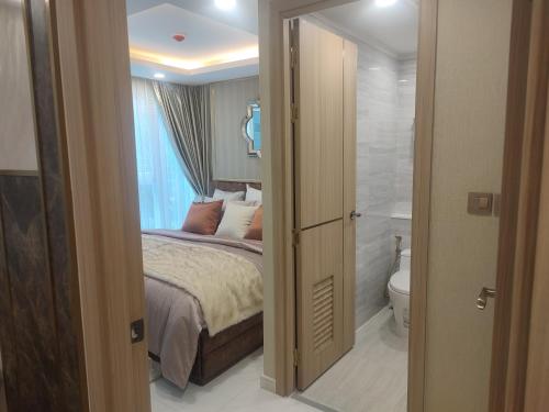 a bedroom with a bed and a bathroom with a toilet at 夏威之宿 in Pattaya North
