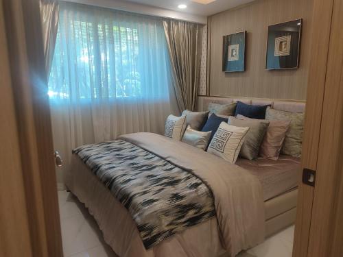 una camera da letto con un grande letto e una finestra di 夏威之宿 a Pattaya North
