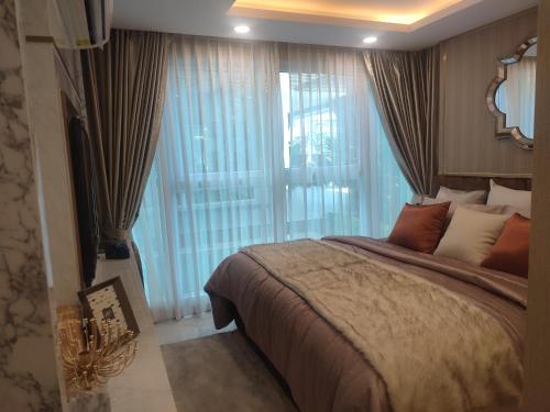 a bedroom with a large bed and a large window at 夏威之宿 in Pattaya North