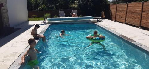 a group of people playing in a swimming pool at Chambre double dans la maison de Pauline et Stéphane in Hommarting