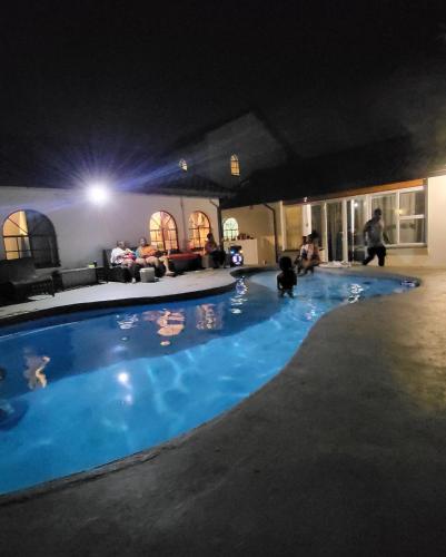 a large swimming pool in a living room at night at Sky view Guest House in Johannesburg