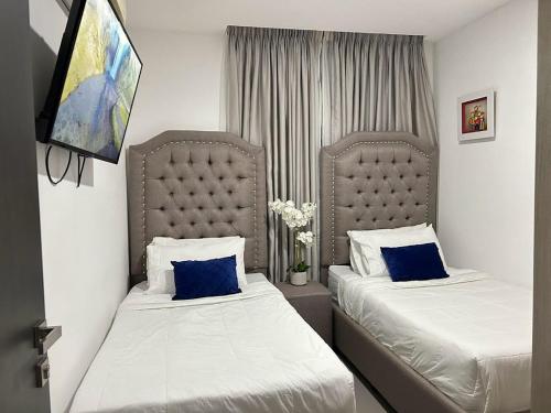 a bedroom with two beds with blue pillows at Elegante y espacioso condominio in San Pedro Sula