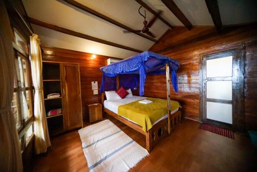 a bedroom with a bed in a wooden cabin at Jardim a Mar in Agonda