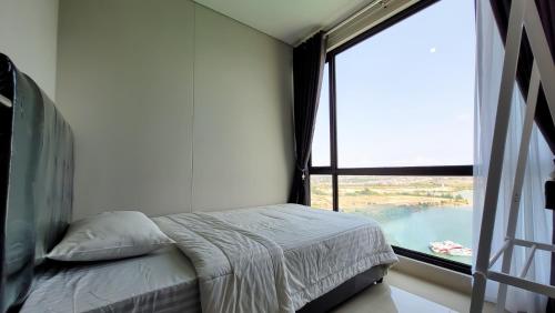 a bedroom with a bed and a large window at Palam Mansion at Apartment One Residence in Batam Center