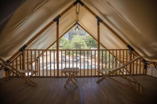 a room with two chairs and a window in a tent at Le lodge de la Catouniere in Castillon-du-Gard