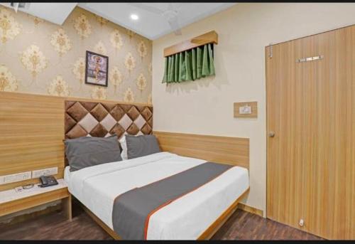 a bedroom with a large bed with a wooden headboard at HOTEL STAY INN in Ahmedabad